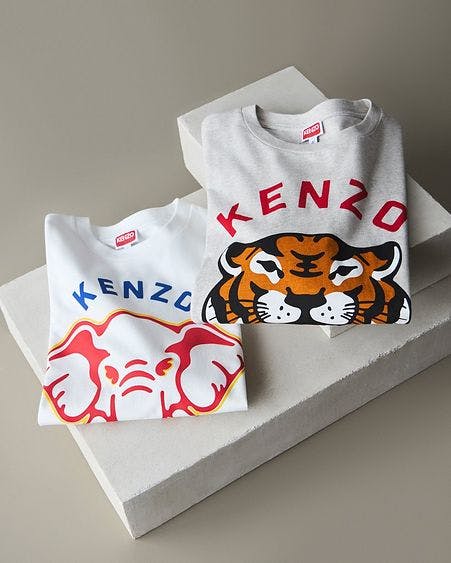 two stacked boxes with kenzo t-shirts folded on top