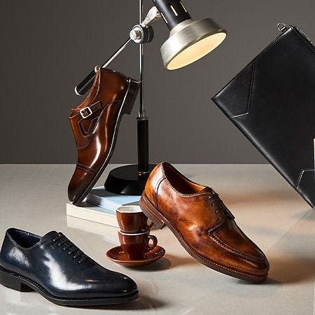 a bunch of dress shoe styles with stationery in the background