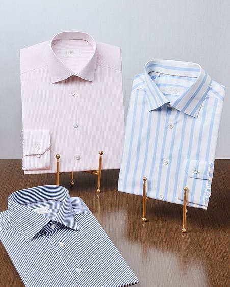 deux chemises habillées affichées sur une chemise standard sur la table