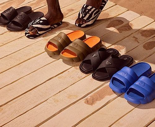 A person standing in front of a row of different colored sandals.