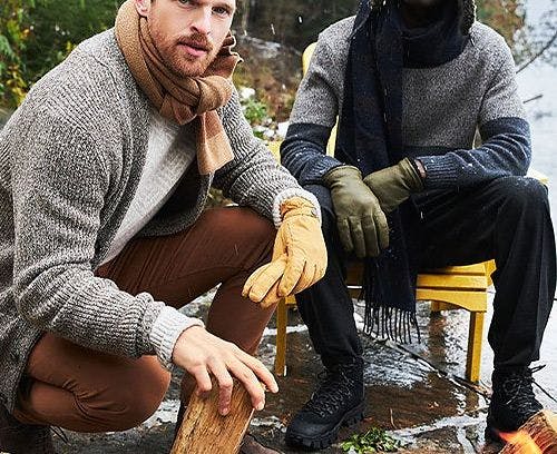 Two men seated, sporting winterwear and ski season accessories